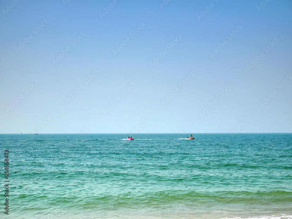 Scenic View of Sea and Horizon with People On Jet Ski and Boat in Distance