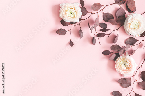 Flowers composition. Pink flowers and eucalyptus leaves on pastel pink background. Flat lay, top view, copy space