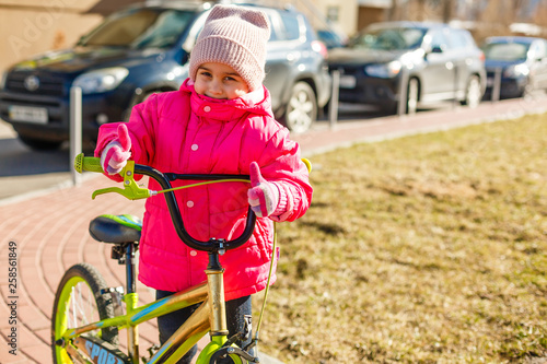 Smiling little girl on a bicycle