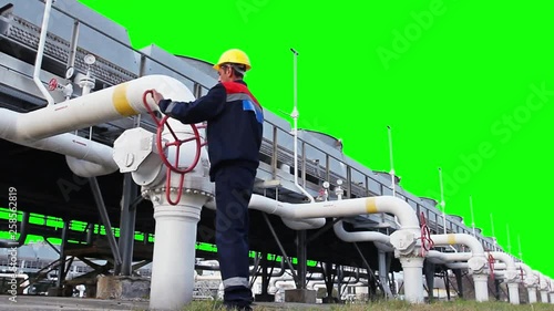 worker opens ball valve on cooling installations of gas compressor station, with alpha channel
