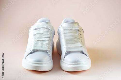 White women's sneakers on a light background. Side view. Close-up.