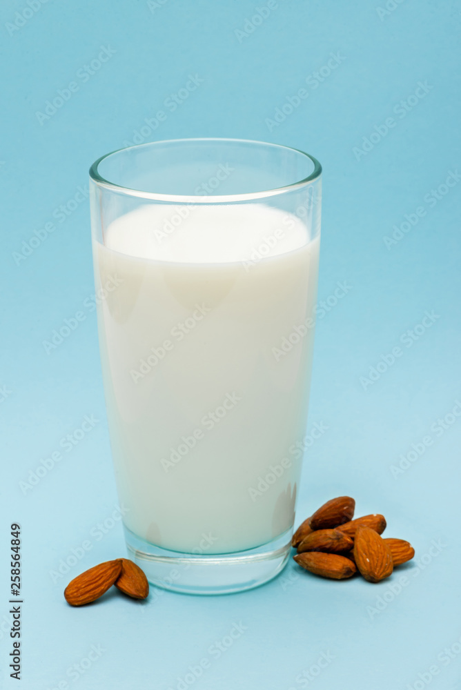 glass of almond milk on blue background glass of almond milk on blue background