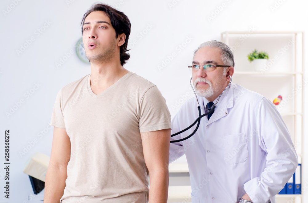 Young male patient visiting old doctor Young male patient visiting old doctor