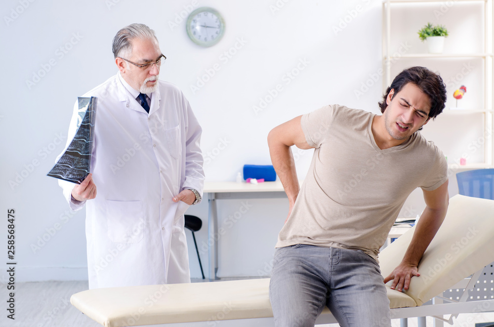 Fototapeta premium Young man visiting old male doctor radiologist 