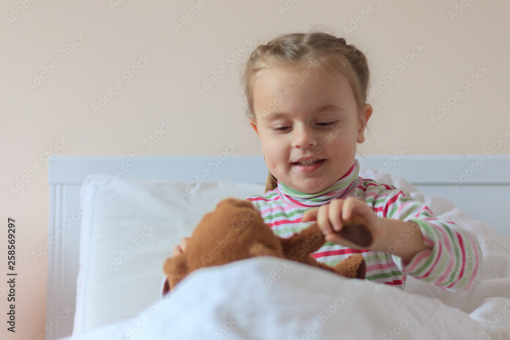 Naklejka premium Little girl holding teddy bear