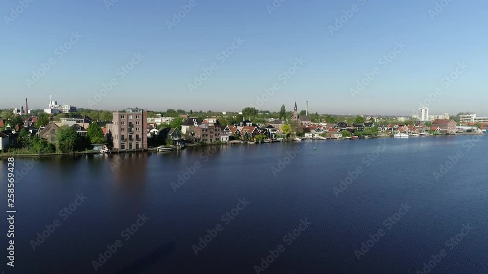 Aerial drone view of windmills of Zaanse Schans, Zaandam near Amsterdam, Netherlands. Sunny day in the spring or summer, morning sun, reflection in lake. Epic shot of wild duck takes off from wetlands Aerial drone view of windmills of Zaanse Schans, Zaandam near Amsterdam, Netherlands. Sunny day in the spring or summer, morning sun, reflection in lake. Epic shot of wild duck takes off from wetlands