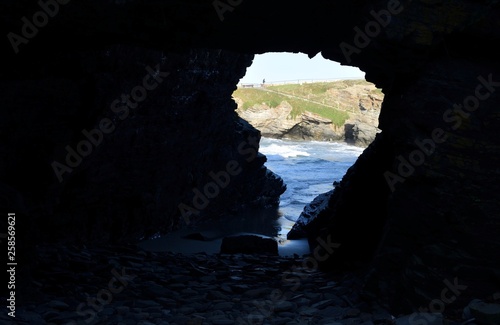 Depuis une grotte, vue sur la promenade de la Plage de Los Castros près de Ribadeo en Galice, Espagne © Ayma