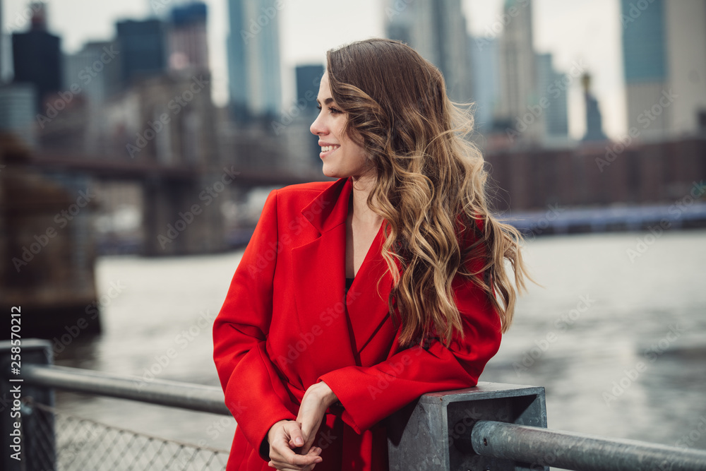 Φωτογραφία Elegant businesswoman with curly hairstyle smiling and looking to the side