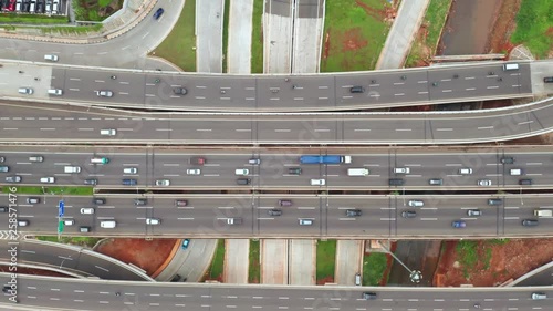 Top down view of Jakarta Outer Ring Road Toll and Depok Antasari interchange with fast traffic from a drone flying upwards. Shot in 4k resolution photo