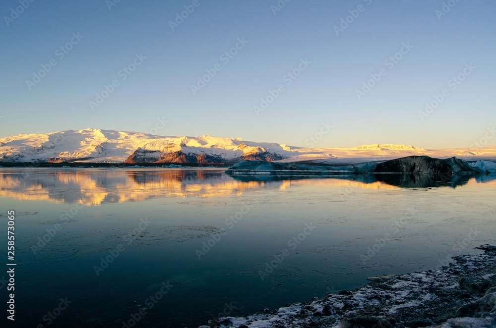 Mirror reflection of Glacier covered mountain during sunrise in Iceland Mirror reflection of Glacier covered mountain during sunrise in Iceland