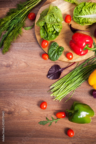 Different raw vegetables on a brown wooden background