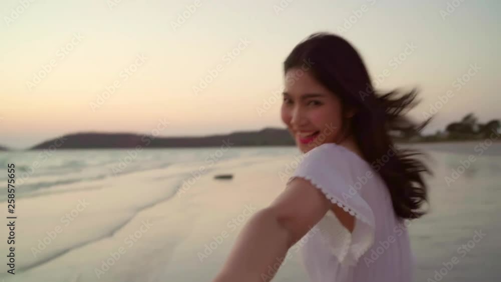 Slow motion - Young Asian couple running and playing on beach, sweet couple have romantic time while honeymoon trip on beach near sea when sunset in evening. Lifestyle couple travel on beach concept. Slow motion - Young Asian couple running and playing on beach, sweet couple have romantic time while honeymoon trip on beach near sea when sunset in evening. Lifestyle couple travel on beach concept.