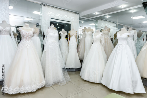 Collection of wedding dresses in showcase of the shop © RomanR