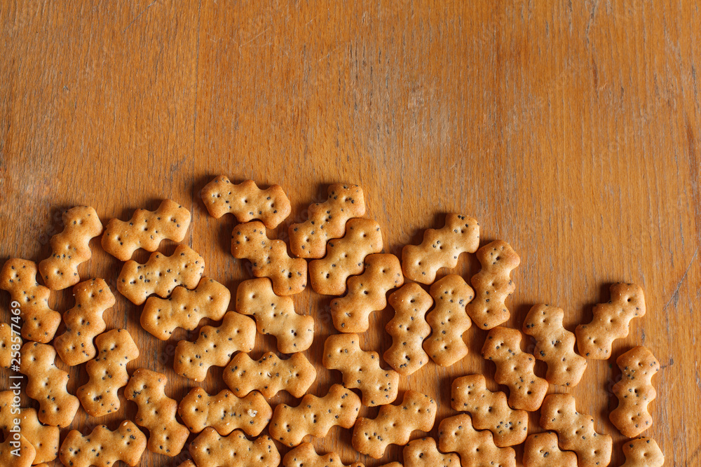 Fototapeta premium Composition of crackers with poppy seeds laid out on a wooden background