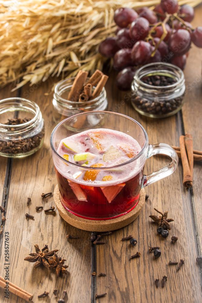 Cup of hot mulled red wine and wheat spikes on wooden table Cup of hot mulled red wine and wheat spikes on wooden table