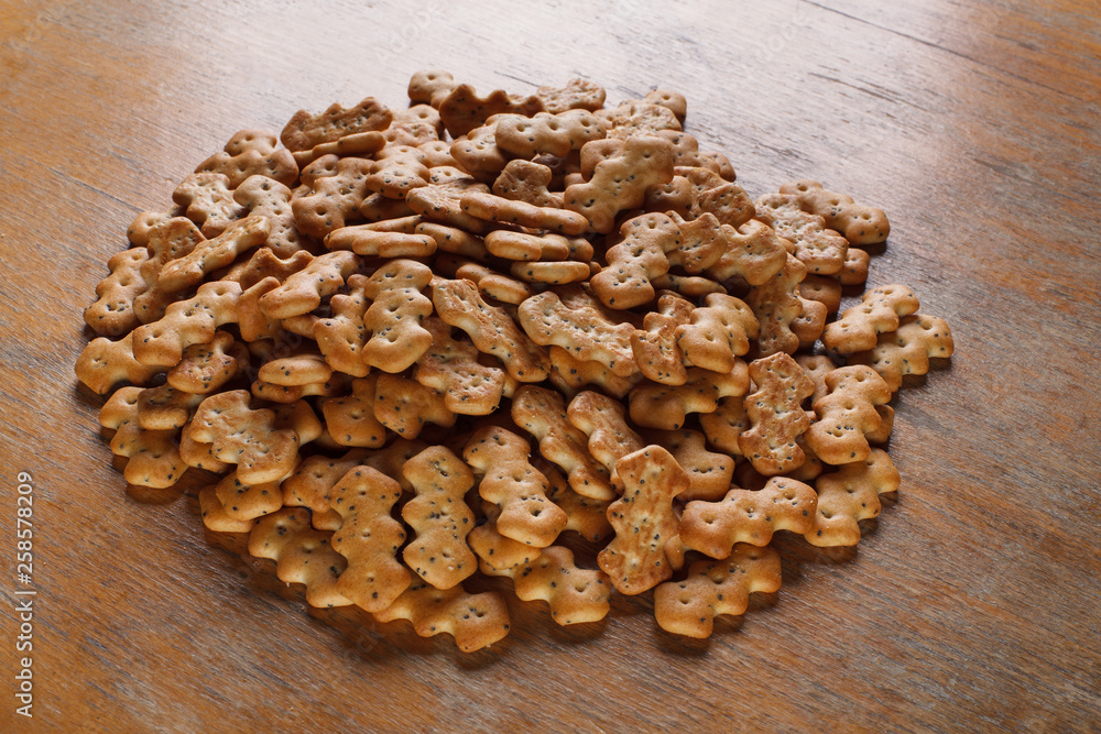 Composition of crackers with poppy seeds, spread out on a wooden background Composition of crackers with poppy seeds, spread out on a wooden background