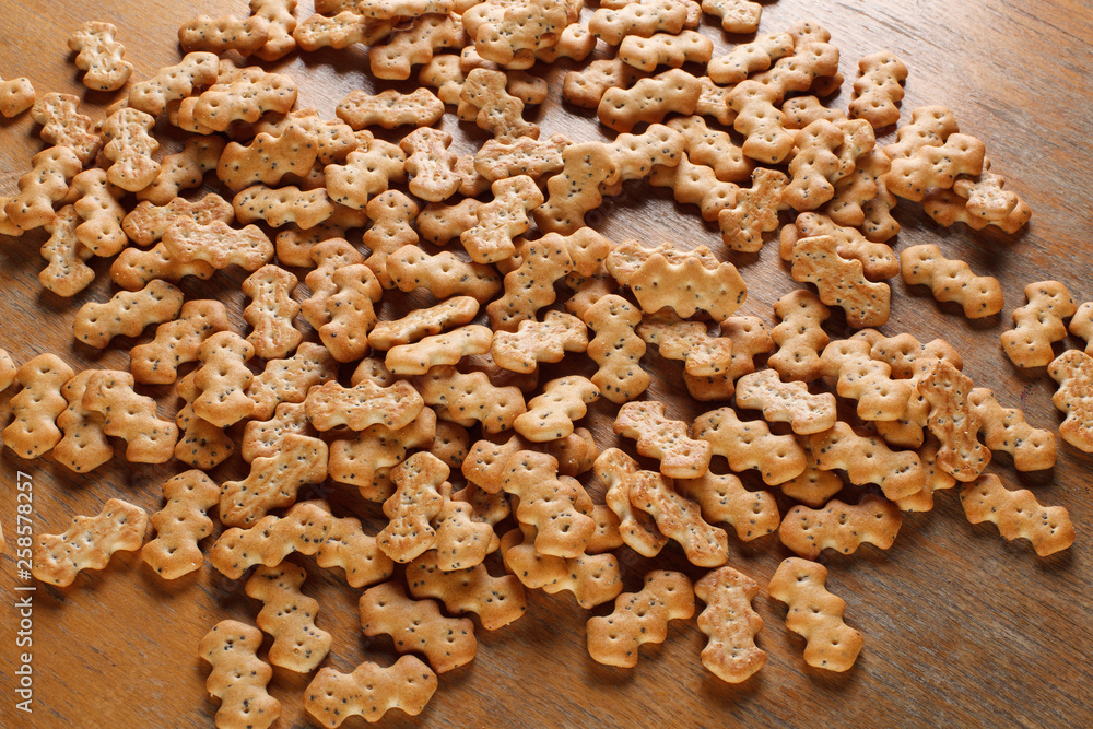 Fototapeta premium Composition of crackers with poppy seeds, spread out on a wooden background