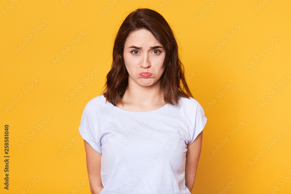 Portrait of offened unhappy beautiful woman withcurves lips, displeased with everything, feels frustrated and very upset, can not go to club. Copy spase for promotional text or advertisment. Portrait of offened unhappy beautiful woman withcurves lips, displeased with everything, feels frustrated and very upset, can not go to club. Copy spase for promotional text or advertisment.