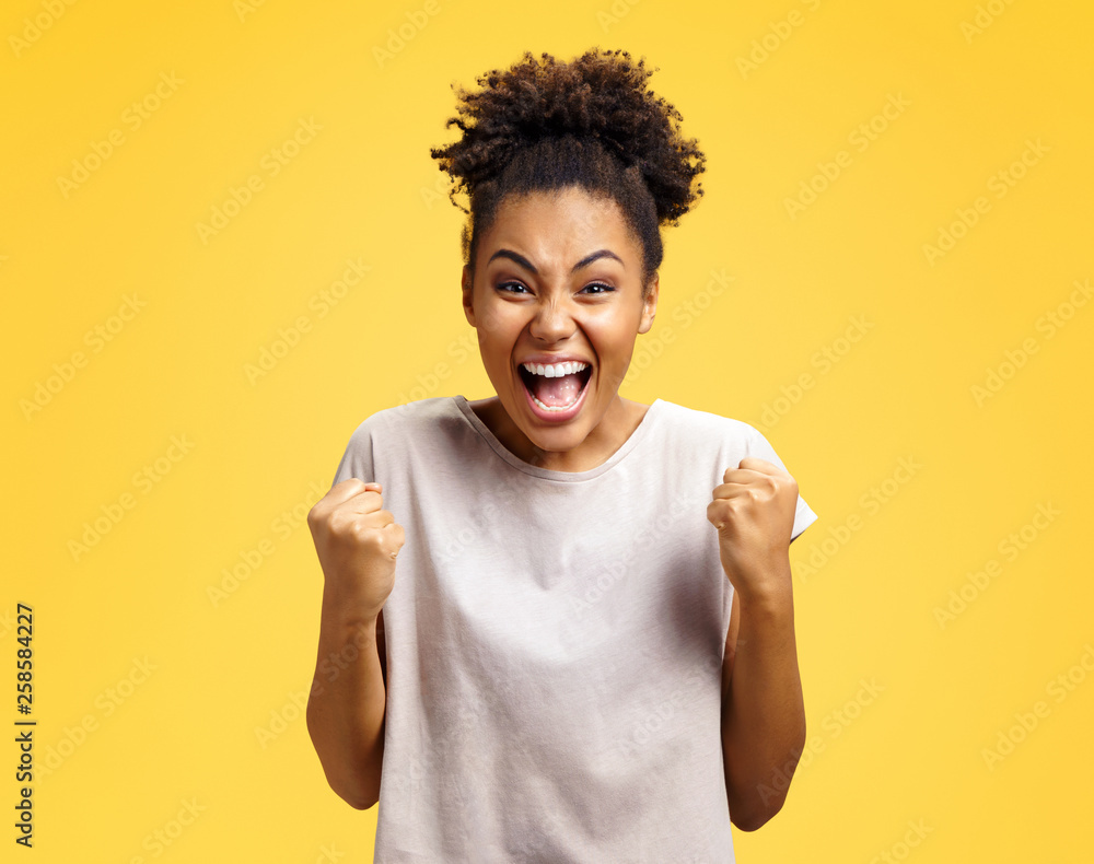 Excited girl with widely open mouth holds hands clenched in fists Excited girl with widely open mouth holds hands clenched in fists