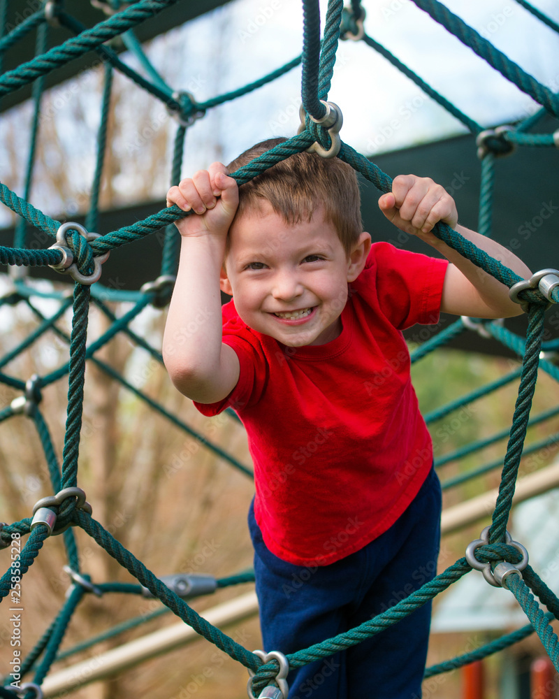 Cute and happy boy playing on playground