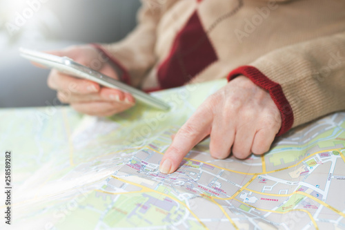 hand with mobile phone pointing to the map, travel and vacation