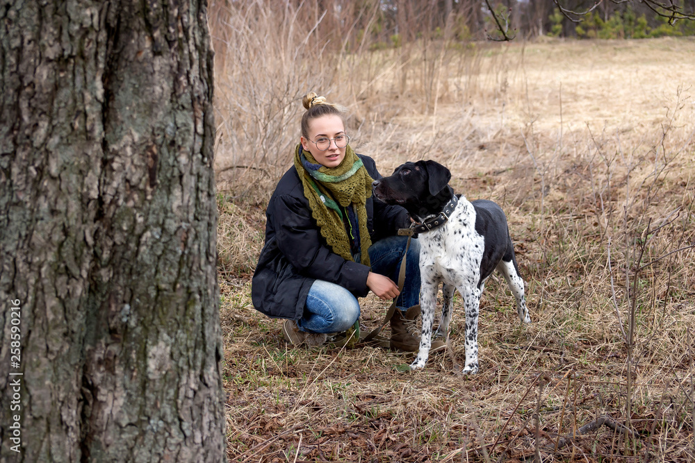 Young brunette girl with her dog walking in autumn park. Young brunette girl with her dog walking in autumn park.
