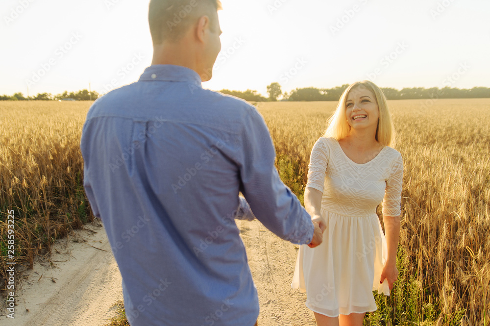 Couple in love holding each other hands in the field