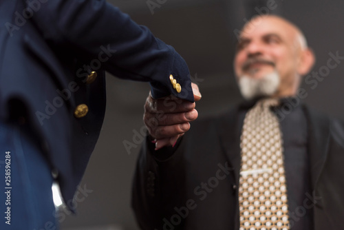 Handshake image of mature boss in office workplace