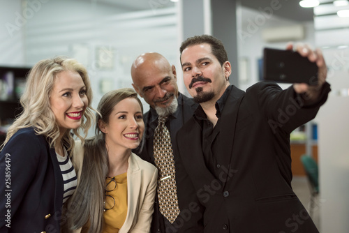 Tableau sur toile Group of people in office looking smartphone and selfies