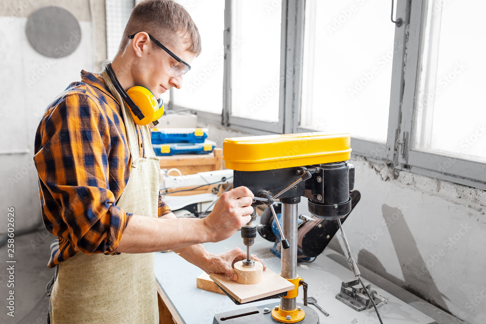 Obraz premium Professional craftsman working on drilling machine in the factory. Concept of technologies and career in the field of manual labor