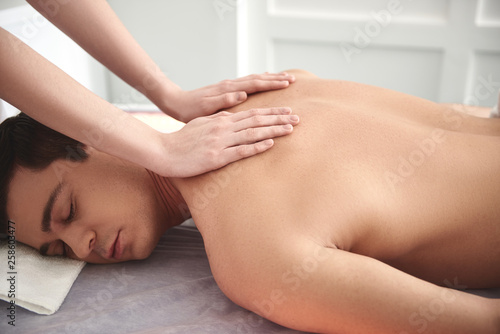 Relaxed caucasian man having massage on table