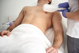 Young man on laser epilation procedure of chest