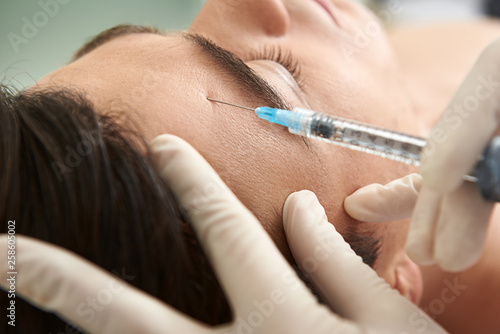 Man on beauty care procedure of forehead skin