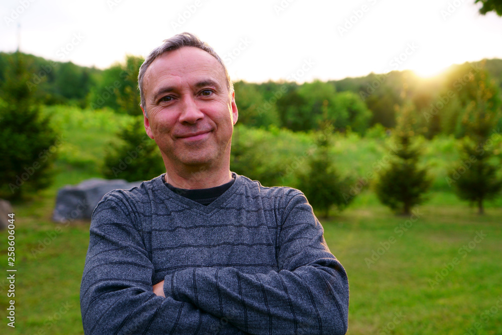 A caucasian man, 50's, is happy and smiling, at sunset, in his rural backyard. A caucasian man, 50's, is happy and smiling, at sunset, in his rural backyard.