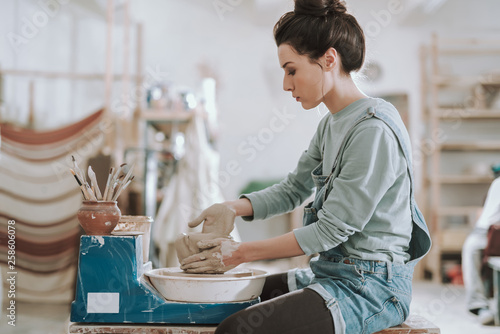 Attractive young lady working on pottery wheel photo