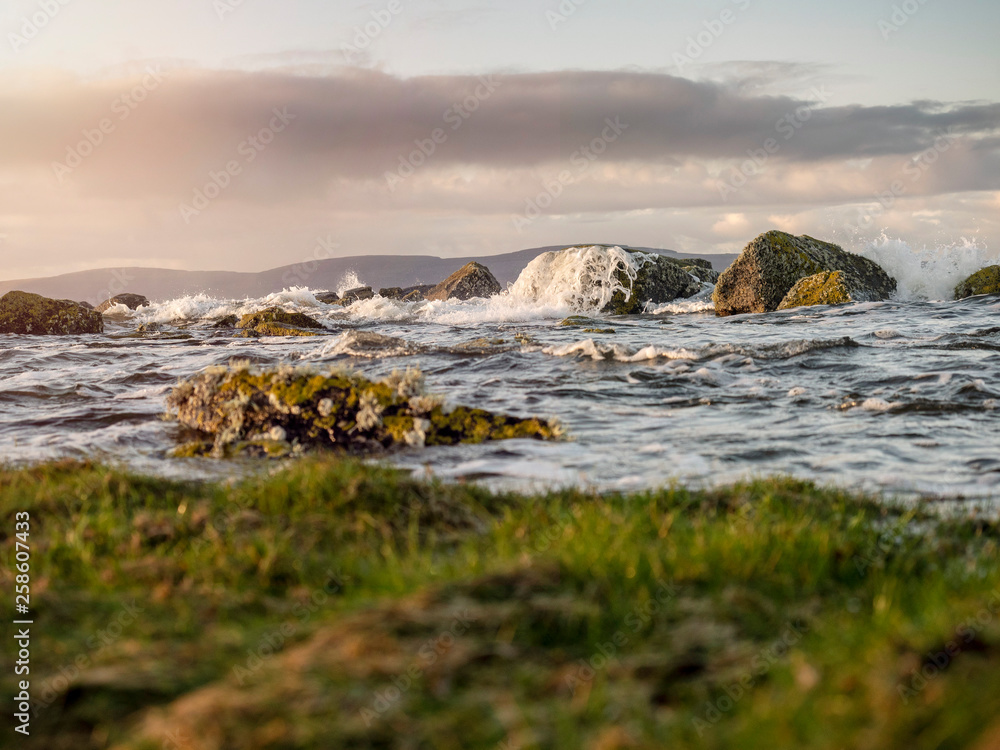 Sunrise on West coast of Ireland, Ocean's wave hit rocks. Cloudy sky. Sunrise on West coast of Ireland, Ocean's wave hit rocks. Cloudy sky.