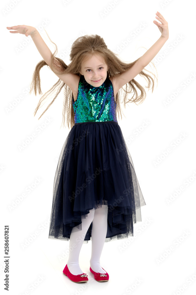 Naklejka premium A little girl fixes her hair.