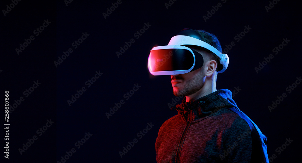Model young man with beard in glasses of virtual reality on dark ...