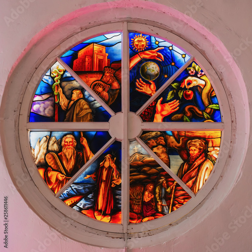 Old round stained glass window in a destroyed in the church, bright colors photo