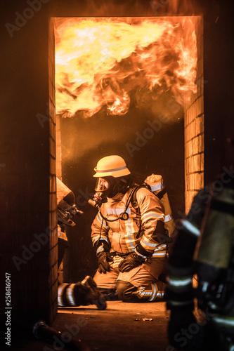 Feuerwehrmänner vor Flammenwand