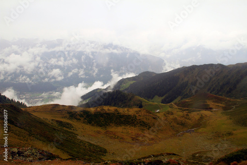 A wet day for the misty rocky mountains covered in snow and surrounded by big thick fog photo