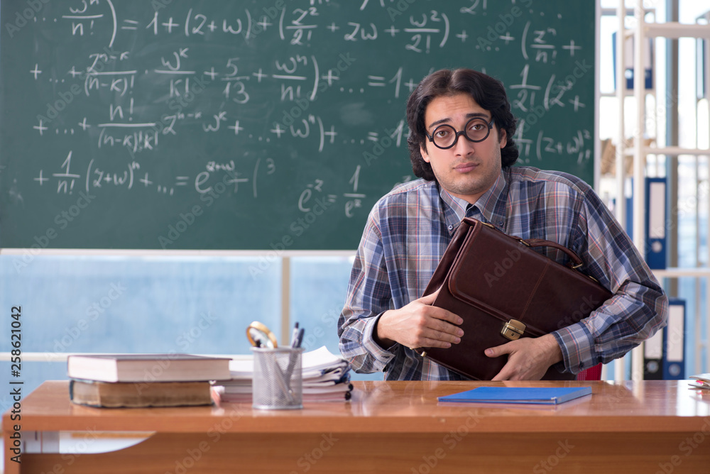 Young funny math teacher in front of chalkboard Young funny math teacher in front of chalkboard