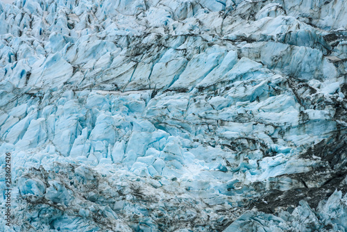Glacial blues and dirt browns in fractured ice patterns on glacier in Drygalski Fjord, South Georgia, as a nature background