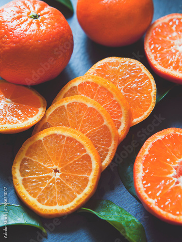 Fresh orange mandarin satsuma tangerine on the grey background - slate background, flat lay, top view position.