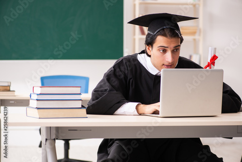 Graduate student in front of green board 