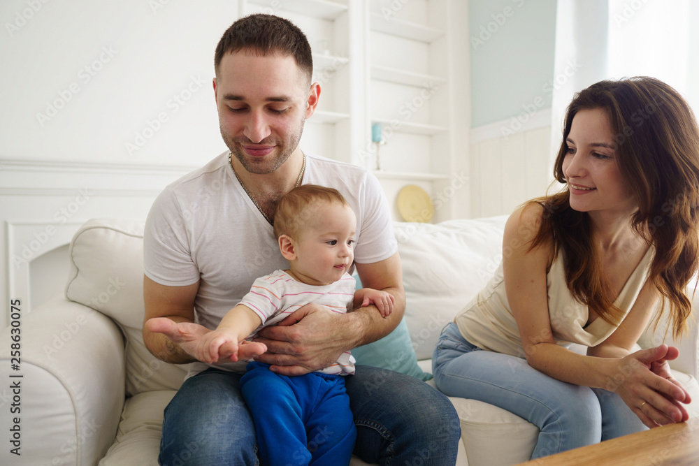 Happy family. Mom, dad and son having fun in living room, parents with baby boy. Childhood, parenthood, family bonds, marriage concept Happy family. Mom, dad and son having fun in living room, parents with baby boy. Childhood, parenthood, family bonds, marriage concept