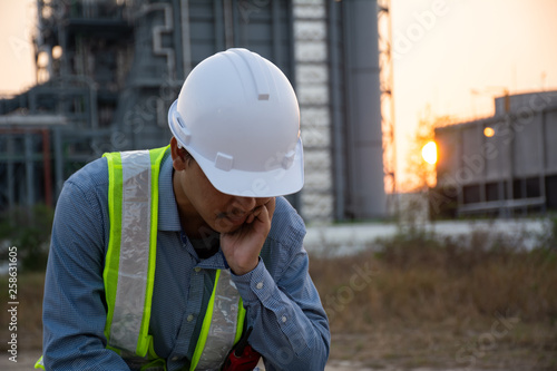 Workers Asian man sitting stressed. at power plant. Energy power station area. concept of Major depressive disorder, unemployed, sadness, depressed and human problems photo