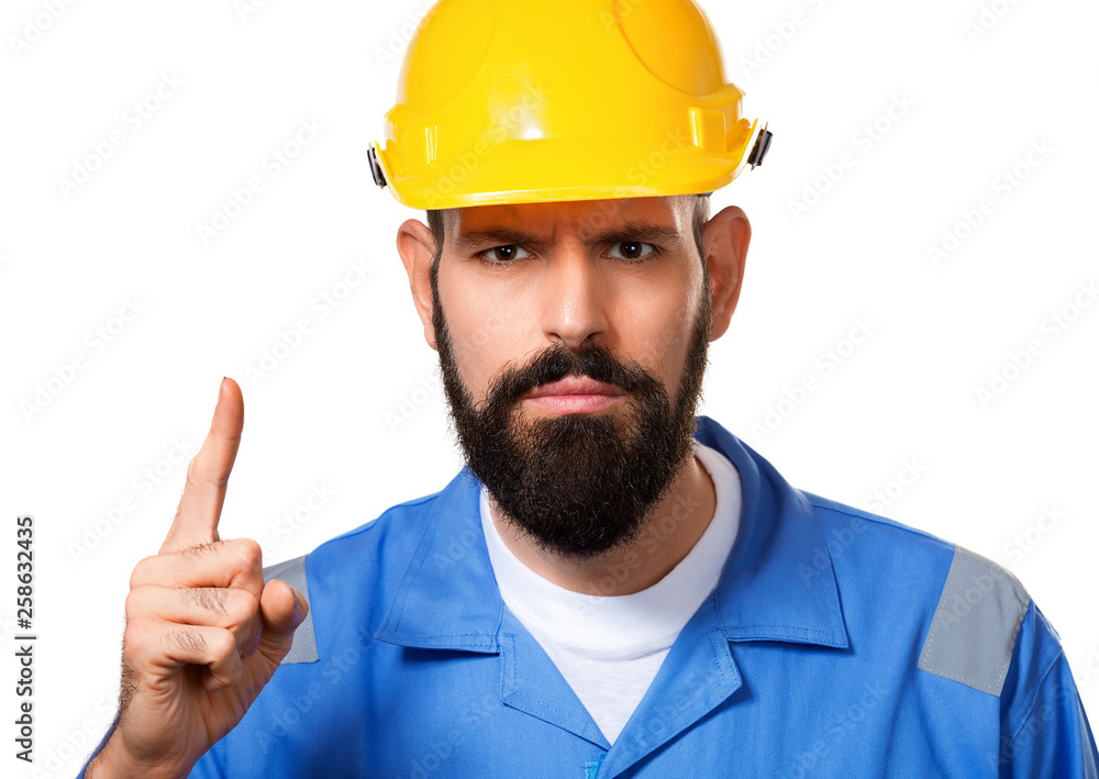 Close up portrait of builder in hard hat, foreman or repairman in the helmet showing finger up. Bearded man worker with beard in building helmet. Isolated