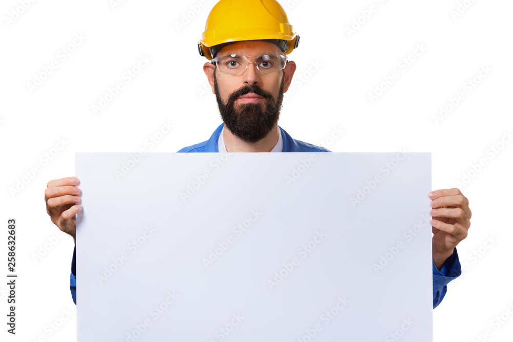 Handsome bearded man worker in protective helmet holding white advertising banner with copy space, isolated on white background. Handsome bearded man worker in protective helmet holding white advertising banner with copy space, isolated on white background.