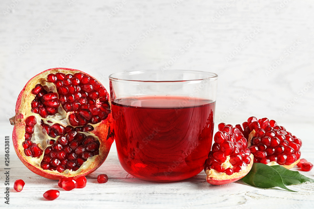 Glass of pomegranate juice and fresh fruits on wooden table Glass of pomegranate juice and fresh fruits on wooden table